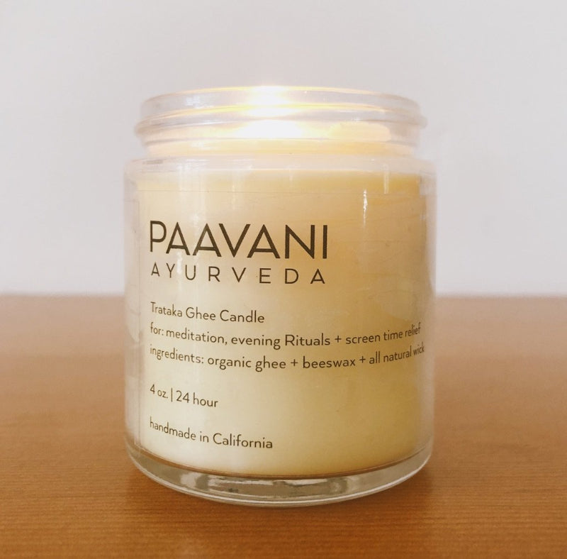 PAAVANI AYURVEDA candle in a glass jar on a wooden surface with a white background
