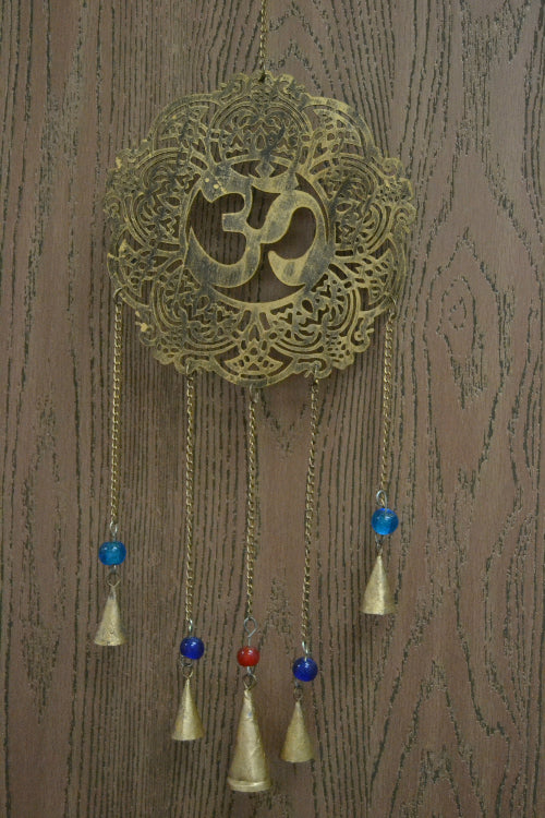 Decorative wall hanging with intricate design and OM symbol on a wooden background