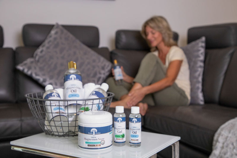 Woman sitting on a couch with a basket of supplements on a coffee table
