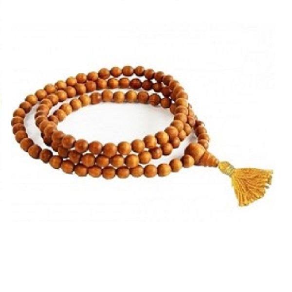 Wooden prayer beads with a yellow tassel on a white background