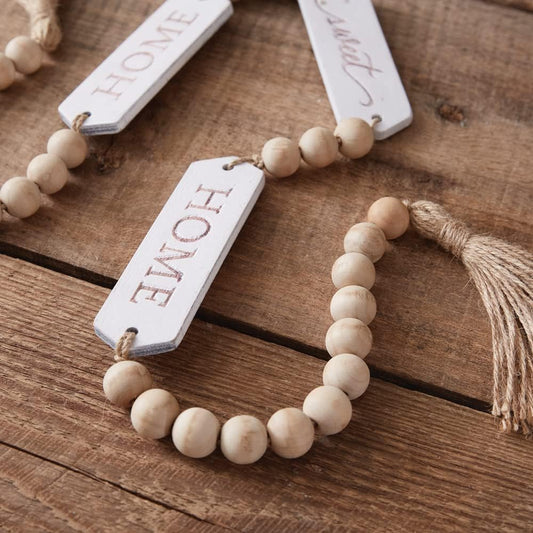 Wooden bead necklace with 'HOME' tag on a wooden surface